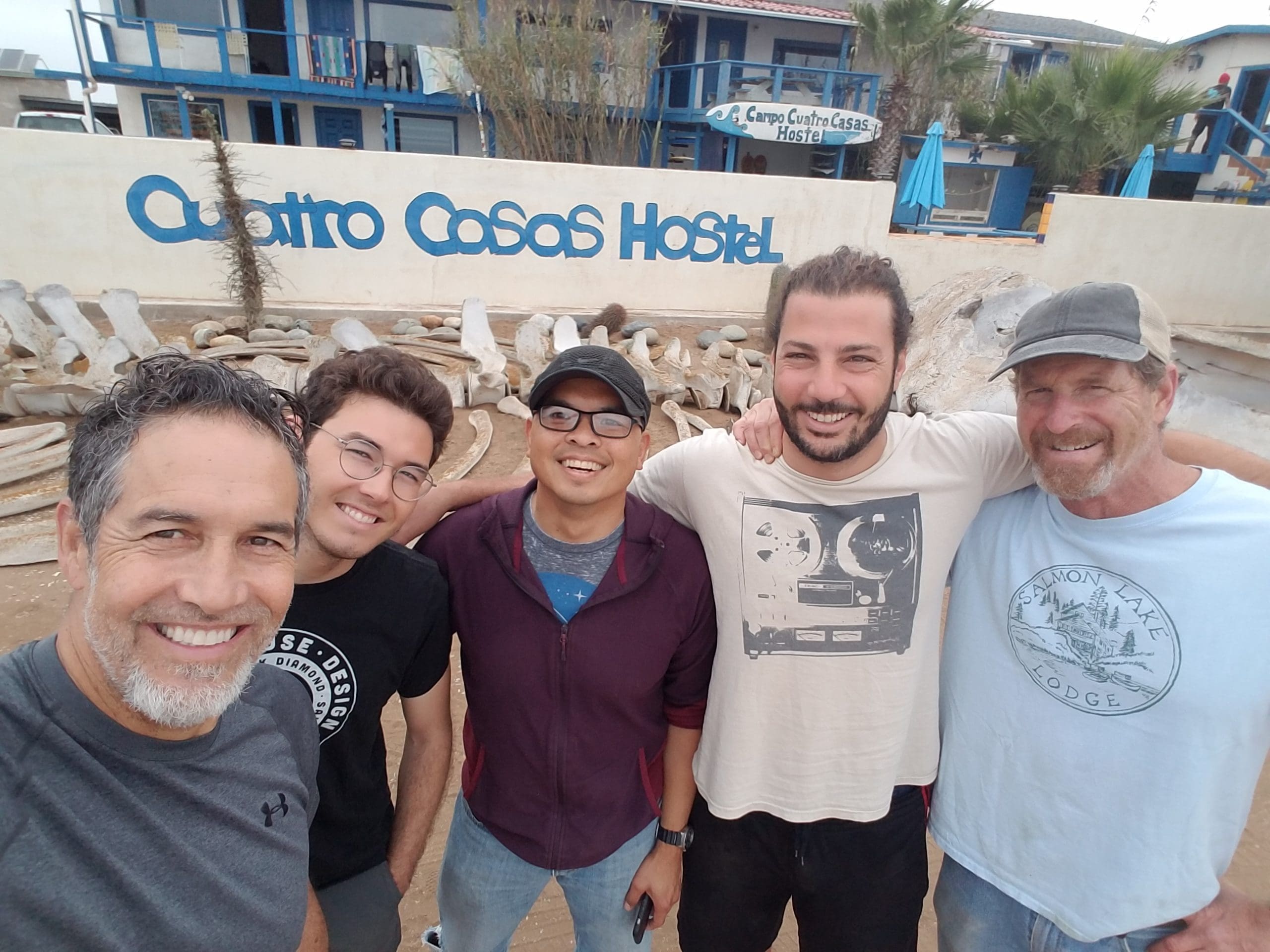 engineering team members at the beach in Baja Mexico with a big set of fossil bones in the background, probably a whale.