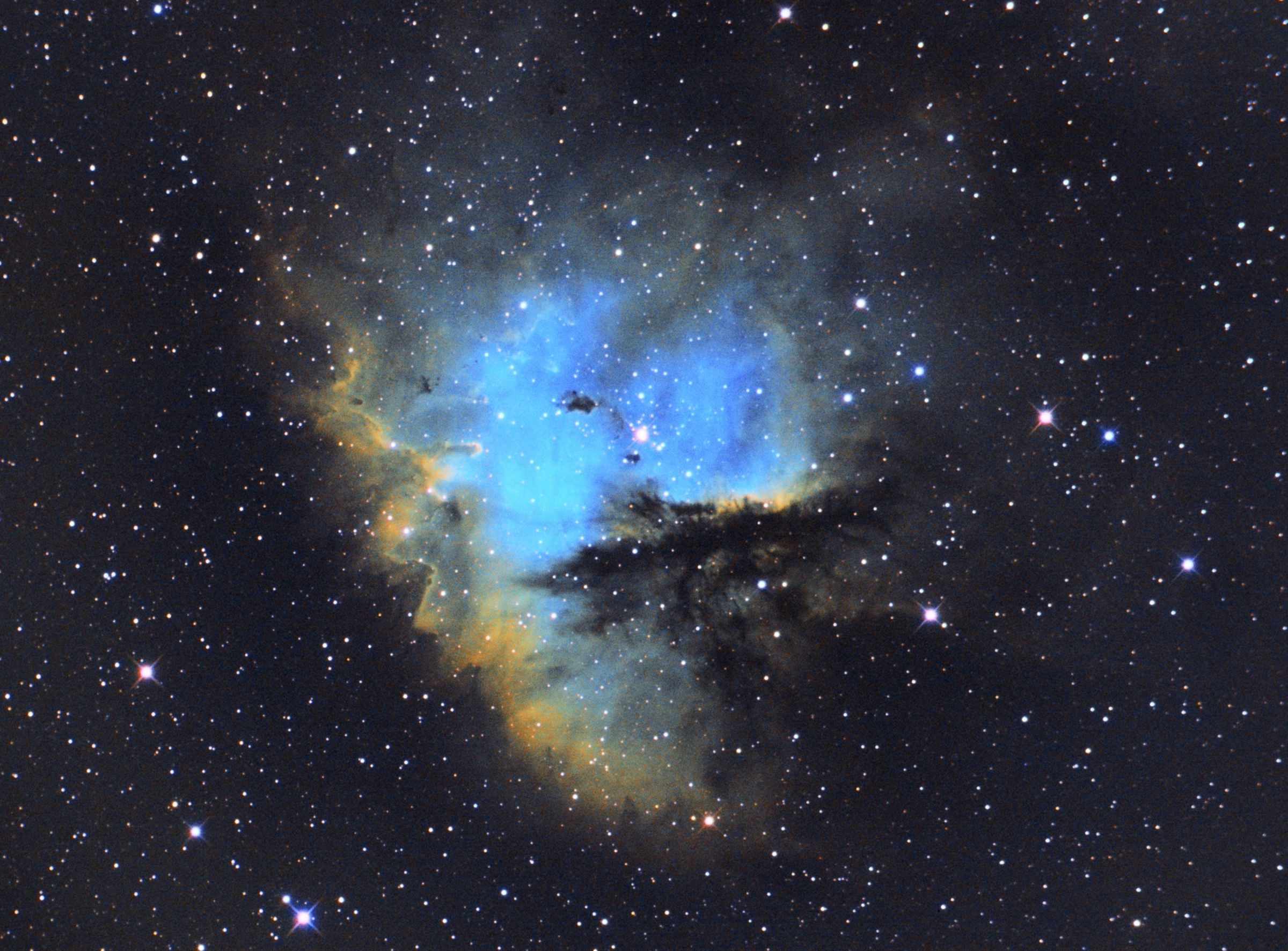 blue and yellow photo of the Pacman Nebula