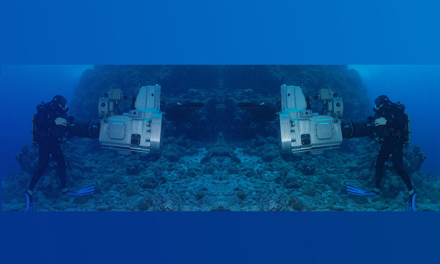 Diver operating 3D underwater video camera in a waterproof housing with